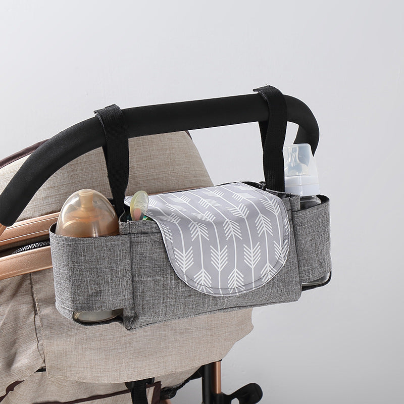 Stroller organizer with bottles and a blanket on a stroller against a light background